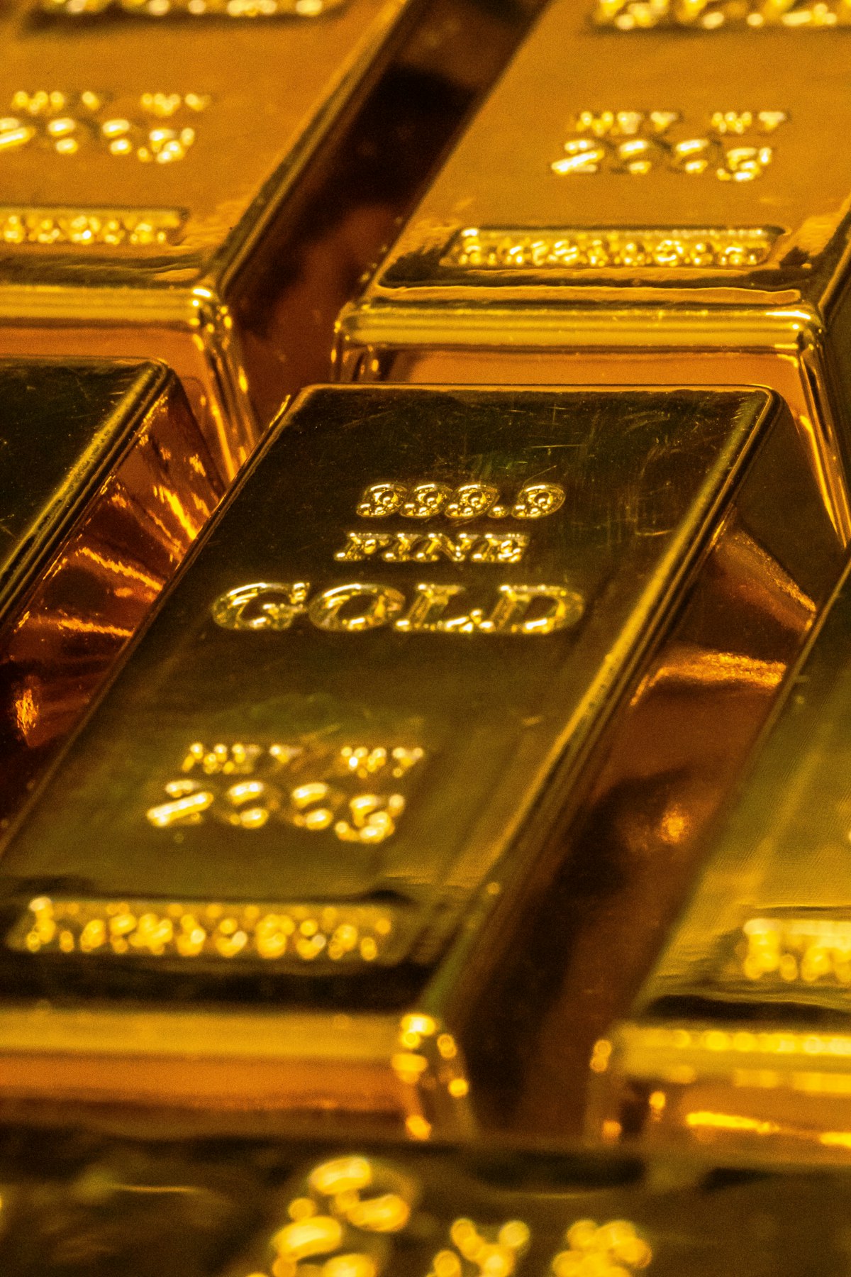 Close view of stacked fine gold bars with stamped markings